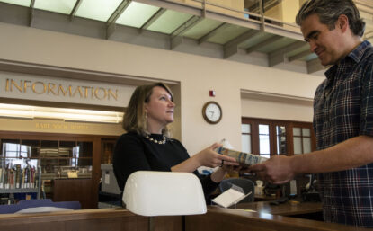 librarian handing a book to a visitor