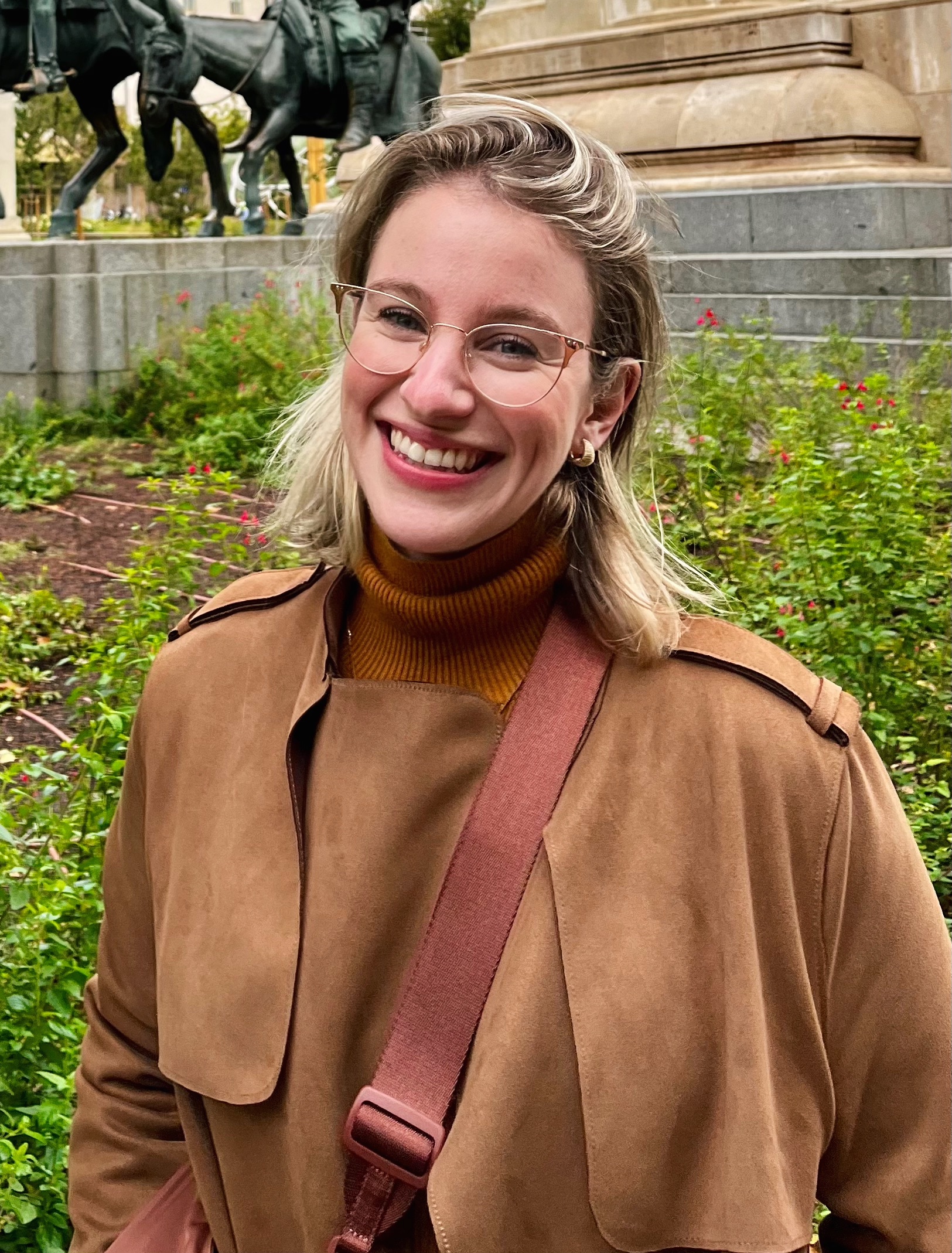 Taylor Dysart in tan suede coat, near statues